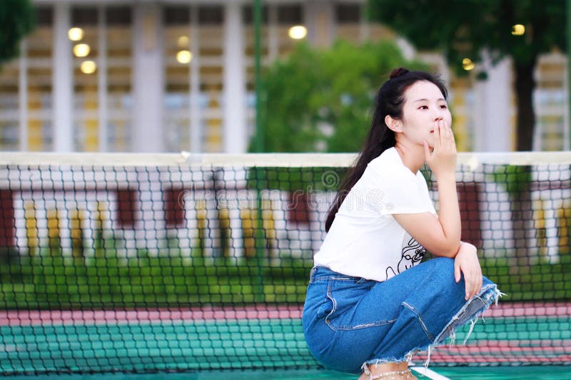 在网球场操场的亚洲中国大学生戏剧 免版税库存图片