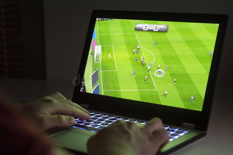 在膝上型计算机的足球或橄榄球电子游戏 年轻人使用
