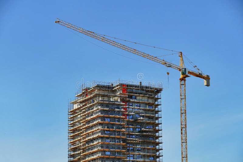 new residential building under construction with a crane on a dismissed industrial area. new residential building under construction with a crane on a dismissed industrial area