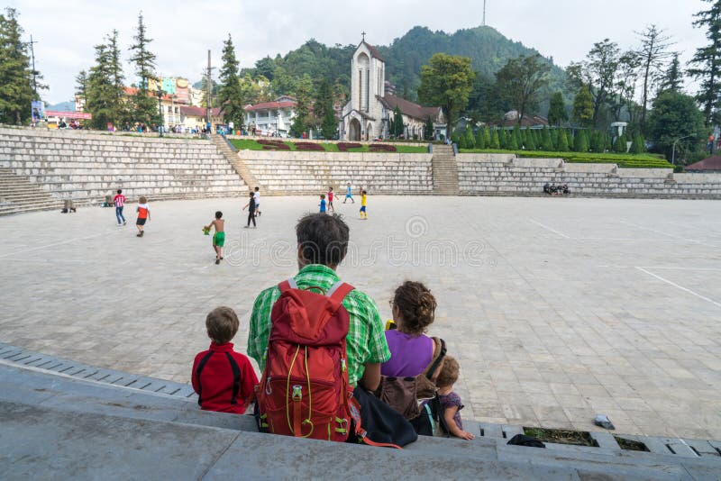 在越南萨帕的广场上坐着家人度假 背包旅行 大家庭成员 免版税库存照片 在越南萨帕的广场上坐着家人度假 背包旅行 大家庭成员 免版税库存照片