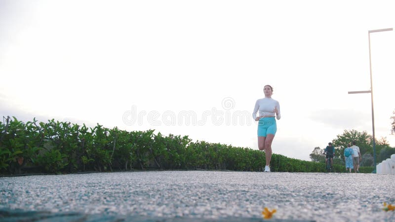 在跑道上慢跑的运动型年轻女子 股票录像