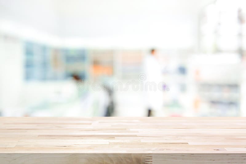 Empty wood counter top on blur pharmacy chemist or cosmetic shop background. Empty wood counter top on blur pharmacy chemist or cosmetic shop background