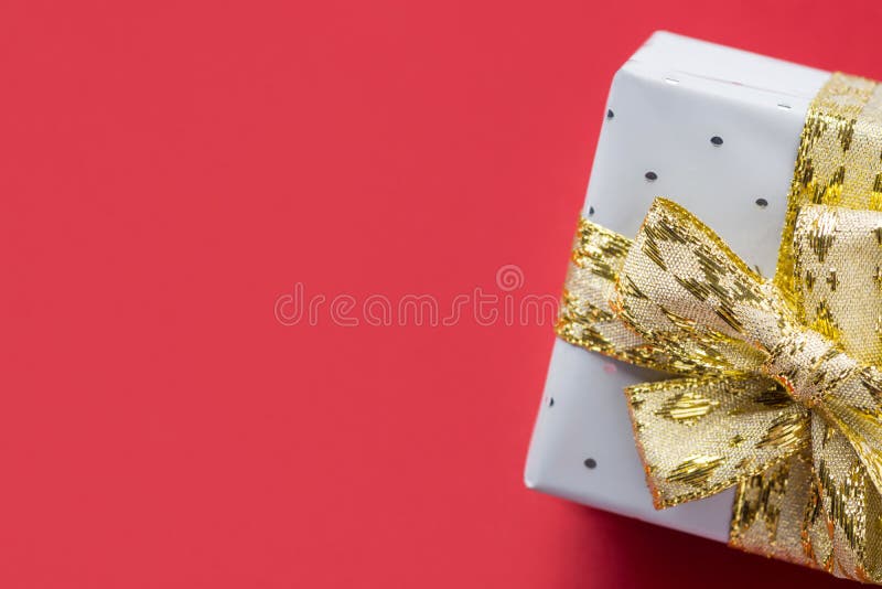 在锡箔包裹的典雅的礼物盒栓有金黄丝带弓深红伯根地背景 圣诞节新年度 免版税库存照片 在锡箔包裹的典雅的礼物盒栓有金黄丝带弓深红伯根地背景 圣诞节新年度 免版税库存照片