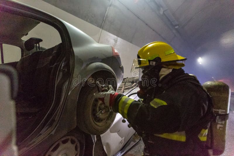 在隧道里面的车祸场面，抢救从汽车的消防队员人 库存图片