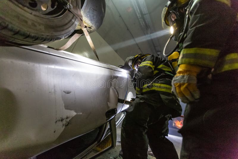在隧道里面的车祸场面，抢救从汽车的消防队员人 库存图片