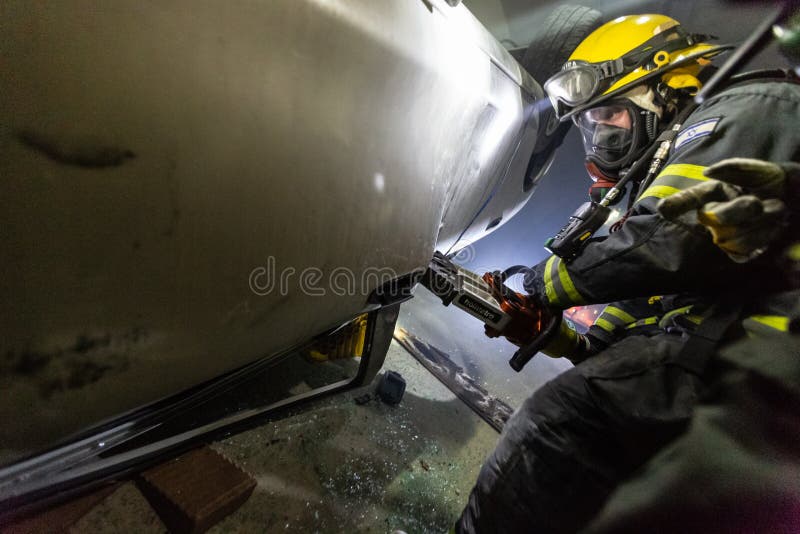 在隧道里面的车祸场面，抢救从汽车的消防队员人 库存图片