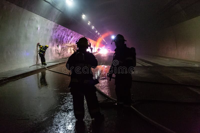 隧道内车祸现场，消防员从车内救出人员 免版税库存照片