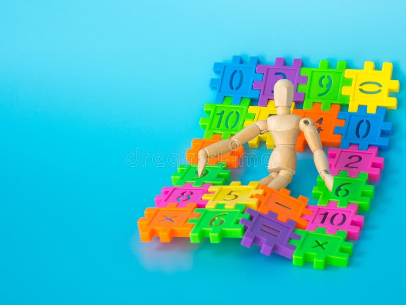 在颜色充分的塑料数字的木木偶睡眠在蓝色背景 苹果登记概念教育红色 复制文本和内容的空间 免版税库存照片 在颜色充分的塑料数字的木木偶睡眠在蓝色背景 苹果登记概念教育红色 复制文本和内容的空间 免版税库存照片