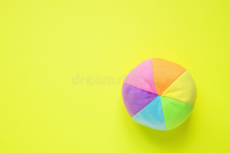 在黄色背景的孩子玩具小长毛绒多彩多姿的纺织品软的球 横幅占位符飘带慈善托儿所医院 图库摄影 在黄色背景的孩子玩具小长毛绒多彩多姿的纺织品软的球 横幅占位符飘带慈善托儿所医院 图库摄影