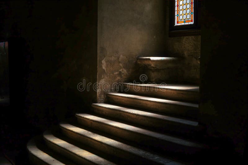 Stone stairway in dark medieval castle dungeon, with a ray of sunlight projected on the steps. Gothic atmosphere, religious ancient building, suggesting mystery and danger. Old haunted Dracula castle in Transylvania. Stone stairway in dark medieval castle dungeon, with a ray of sunlight projected on the steps. Gothic atmosphere, religious ancient building, suggesting mystery and danger. Old haunted Dracula castle in Transylvania.