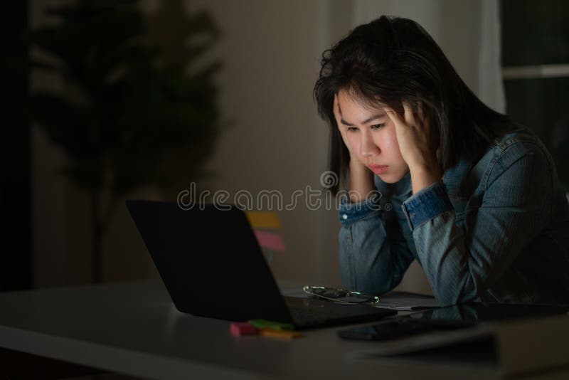 坦率年轻亚裔唯一女生工作夜间注重与项目在计算机膝上型计算机的研究问题或 库存照片 坦率年轻亚裔唯一女生工作夜间注重与项目在计算机膝上型计算机的研究问题或 库存照片