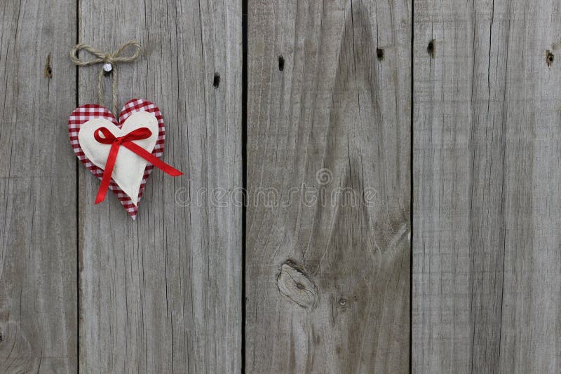 红色格纹和棉布心形挂在木门上 免版税图库摄影