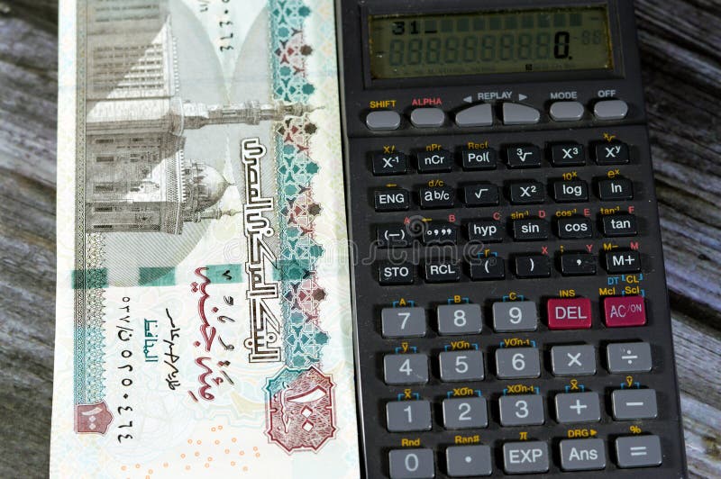 100 EGP LE one hundred Egyptian pound bills with Sultan Hassan mosque on it, Pile Egypt cash money bill with a calculator beside it, exchange rates of currencies with the Egyptian pound concept. 100 EGP LE one hundred Egyptian pound bills with Sultan Hassan mosque on it, Pile Egypt cash money bill with a calculator beside it, exchange rates of currencies with the Egyptian pound concept