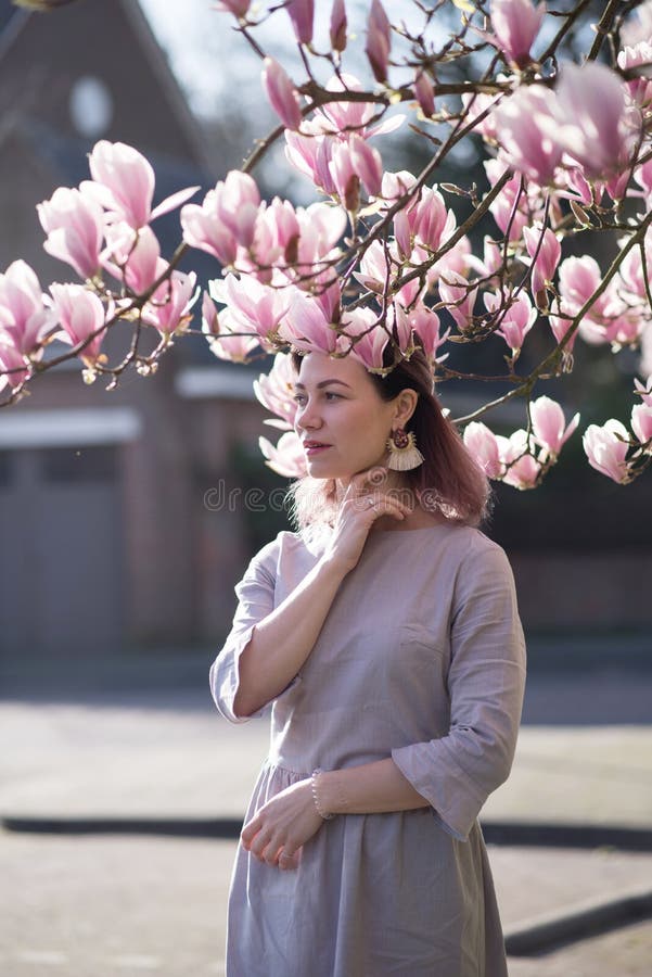 城市公园中美丽的年轻时尚女人 春花 花木兰树附近休闲时髦服装中的浪漫女孩 图库摄影 城市公园中美丽的年轻时尚女人 春花 花木兰树附近休闲时髦服装中的浪漫女孩 图库摄影