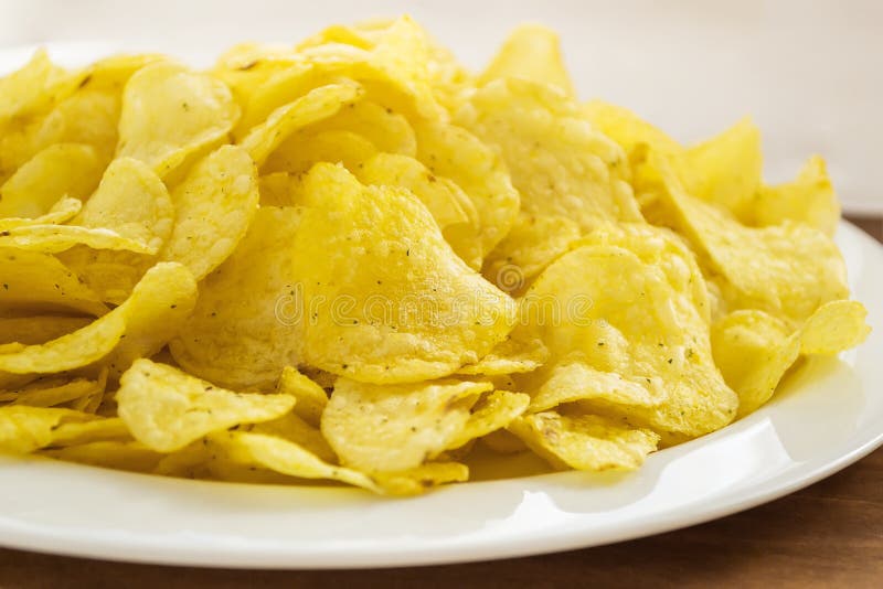堆在一块白色板材的酥脆薯片在桌上 便当和鲜美快餐概念 库存照片 堆在一块白色板材的酥脆薯片在桌上 便当和鲜美快餐概念 库存照片