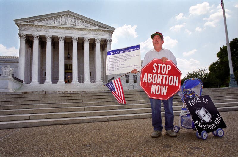 WASHINGTON, DC - MAY 14: An anti-abortion protester holds a stop sign and the Ten Commandments on the sidewalk in front of the U.S. Supreme Court on May 14, 2001. WASHINGTON, DC - MAY 14: An anti-abortion protester holds a stop sign and the Ten Commandments on the sidewalk in front of the U.S. Supreme Court on May 14, 2001.