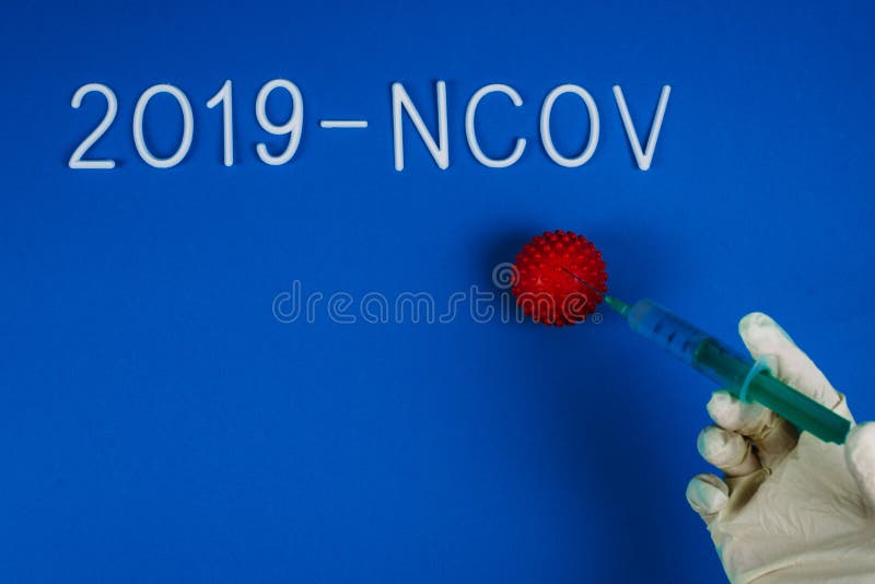 塑料白手套的医生将注射器注射到冠状病毒的红色球中 治疗中国感染 2019- 免版税库存图片 塑料白手套的医生将注射器注射到冠状病毒的红色球中 治疗中国感染 2019- 免版税库存图片