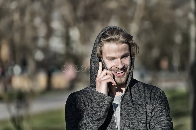 塑造强壮男子微笑与在偶然运动衫的智能手机 敞篷谈话的愉快的人在晴朗室外的手机 有胡子的人s 免版税库存图片 塑造强壮男子微笑与在偶然运动衫的智能手机 敞篷谈话的愉快的人在晴朗室外的手机 有胡子的人s 免版税库存图片