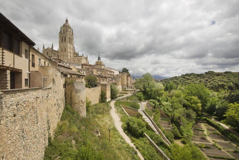 Cityscape of Segovia with the cathedral on the hill, the ancient city walls and other buildings and trees in Spain. Cityscape of Segovia with the cathedral on the hill, the ancient city walls and other buildings and trees in Spain