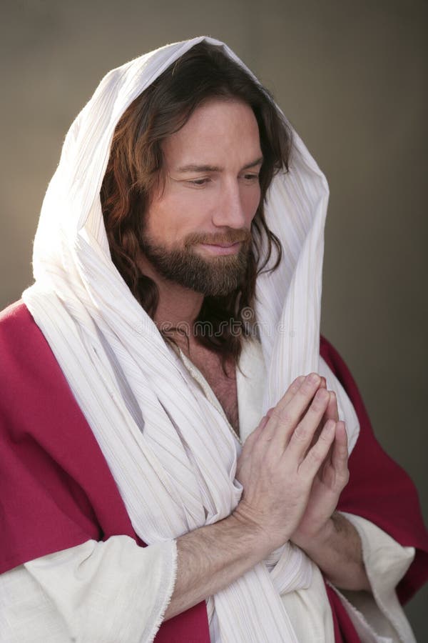 Jesus Christ Portrait praying image back lit with hands in prayer offering a loving blessing and deep love and gratitude. Jesus Christ Portrait praying image back lit with hands in prayer offering a loving blessing and deep love and gratitude