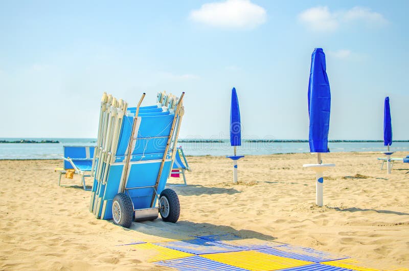 end of summer beach deckchair closed umbrella. end of summer beach deckchair closed umbrella.