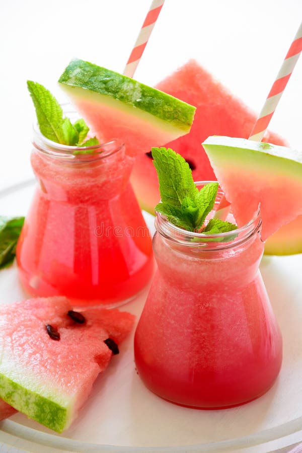 Summer watermelon smoothie decorated mint leaves on pink background. Summer drink concept. Summer watermelon smoothie decorated mint leaves on pink background. Summer drink concept.