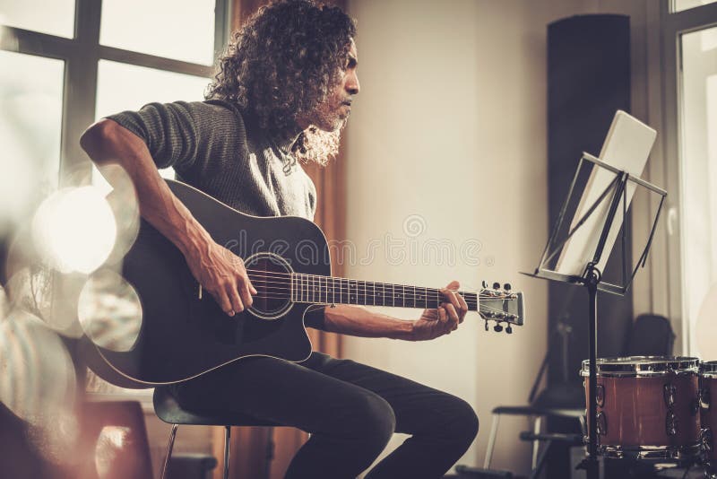 多年弹吉他的严肃男人. 免版税库存照片
