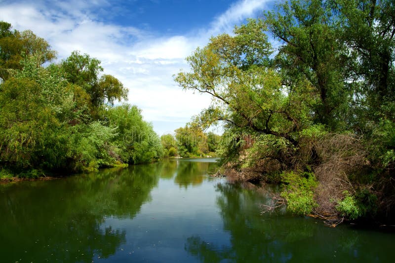 Channel landscape in Danube Delta on blue sky with clouds. Channel landscape in Danube Delta on blue sky with clouds