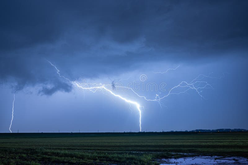 Dazzling thunderbolt is hitting earth during a fierce lightning storm at night. Dazzling thunderbolt is hitting earth during a fierce lightning storm at night.