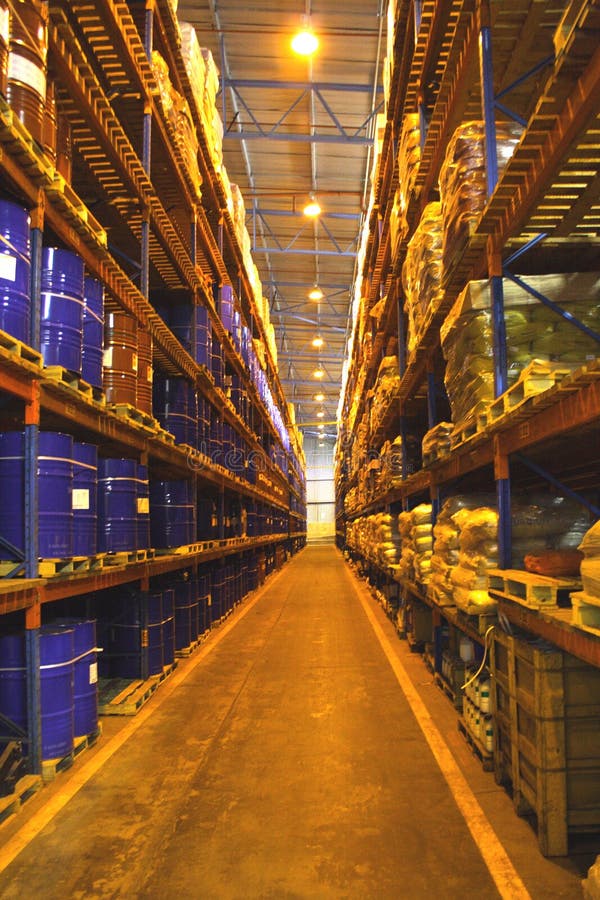 Tall shelves inside warehouse with blue tins and palettes. Tall shelves inside warehouse with blue tins and palettes.