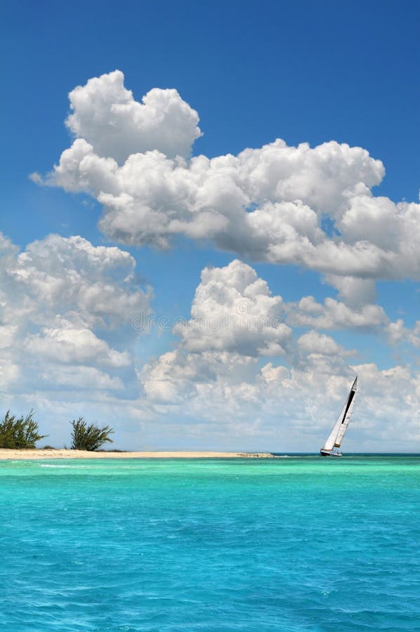 Sailboat sailing clear waters by tropical island. Sailboat sailing clear waters by tropical island