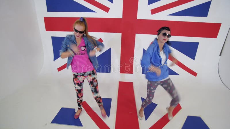 太阳镜锻炼的热的少妇有英国旗子的演播室跳舞移动