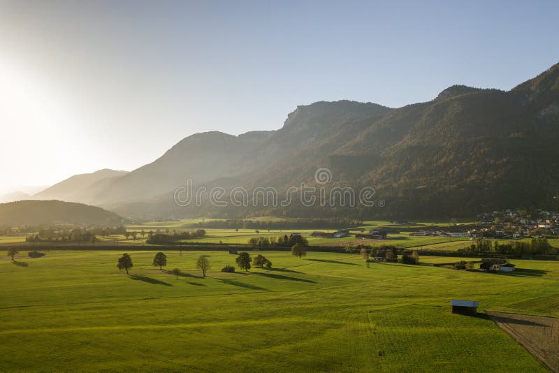 奥地利阿尔卑斯山绿草地与村庄及森林的空中景观 免版税图库摄影