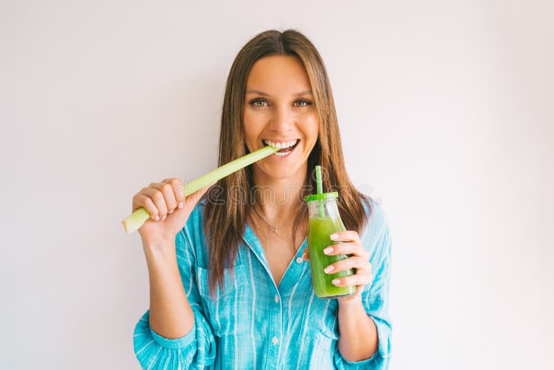 Healthy detox vegan diet. Young beautiful woman eating a stick of green organic celery and drinking fresh homemade celery juice from a glass bottle. High quality photo. Healthy detox vegan diet. Young beautiful woman eating a stick of green organic celery and drinking fresh homemade celery juice from a glass bottle. High quality photo