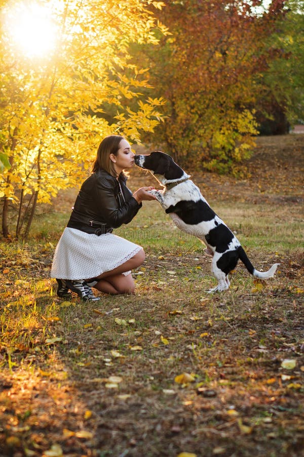 女孩和狗在秋天公园