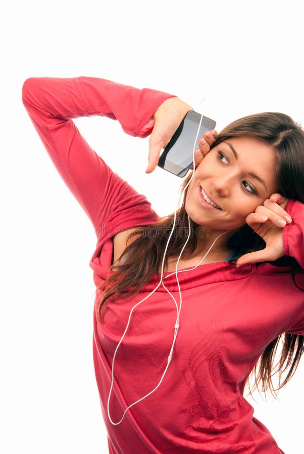 Pretty young woman listening music on her new cellular touch mp3 player in headphones wearing dance pink top, isolated on white background. Pretty young woman listening music on her new cellular touch mp3 player in headphones wearing dance pink top, isolated on white background