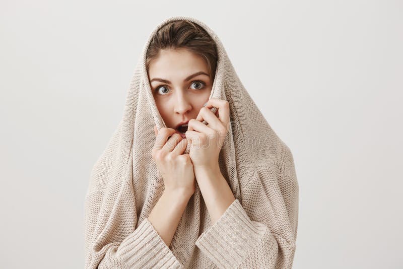 女孩观看单独恐怖电影,打颤从恐惧 可爱的欧洲女性拉扯的毛线衣画象在头的和 免版税图库摄影 女孩观看单独恐怖电影,打颤从恐惧 可爱的欧洲女性拉扯的毛线衣画象在头的和 免版税图库摄影