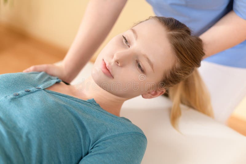 女性理疗或脊椎按摩器调整患者颈部. 理疗康复概念. 侧视图裁剪.