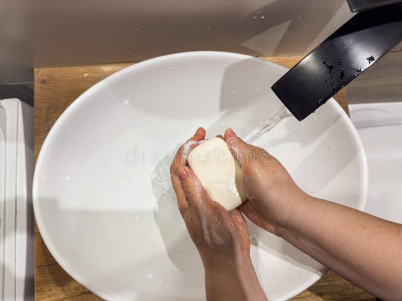 Woman washing hands under the faucet with soap in bathroom to prevent coronavirus infection. Hygiene concept. Woman washing hands under the faucet with soap in bathroom to prevent coronavirus infection. Hygiene concept