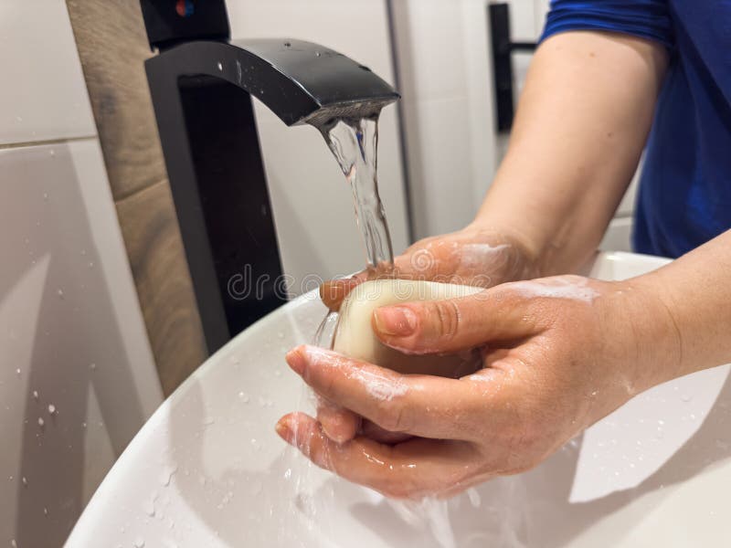 Woman washing hands under the faucet with soap in bathroom to prevent coronavirus infection. Hygiene concept. Woman washing hands under the faucet with soap in bathroom to prevent coronavirus infection. Hygiene concept
