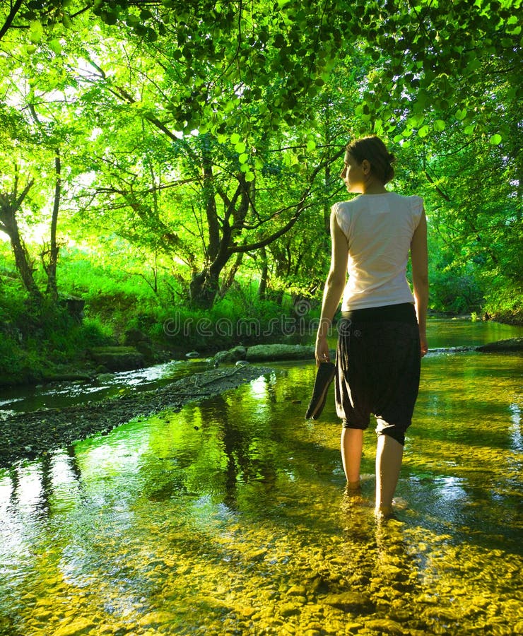 Young beautiful woman relaxing in river at sunset in summer. Young beautiful woman relaxing in river at sunset in summer