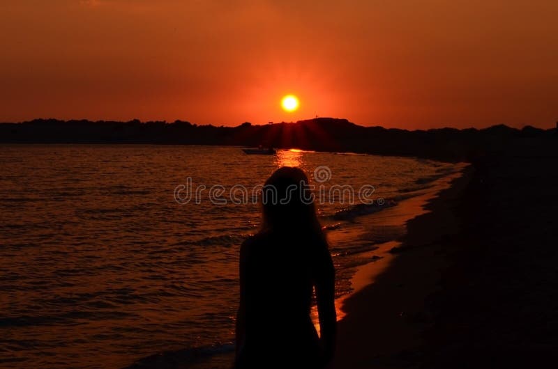妇女剪影海滩的反对在日落期间的天空 免版税库存照片 妇女剪影海滩的反对在日落期间的天空 免版税库存照片