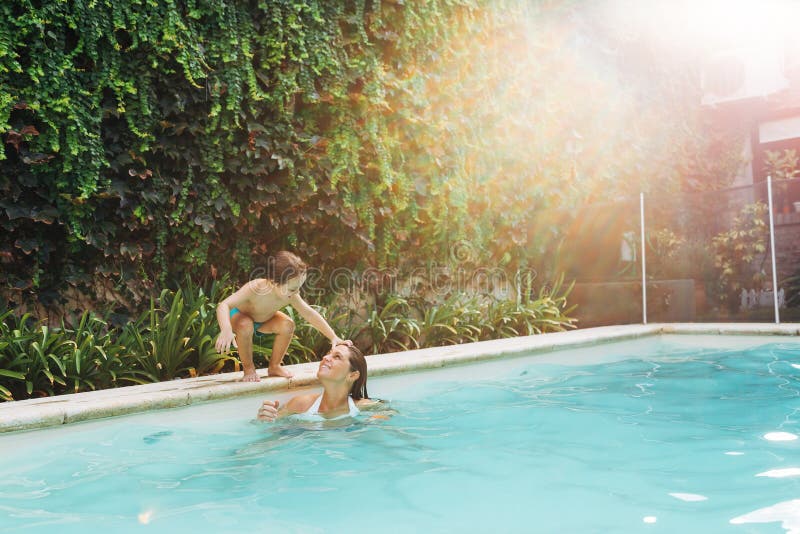 Mom an son get fun in a swimming pool. Summer season indoors. Mom an son get fun in a swimming pool. Summer season indoors.