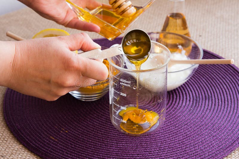 Preparation of the Turmeric face mask receipt set. Add honey over mixture in the beaker. Ingredients: -1/2 teaspoon turmeric powder -½ teaspoon organic apple cider vinegar -one tablespoon of organic, raw, bee honey -½ teaspoon milk or yogurt -one drop lemon essential oil or fresh lemon juice for skin brightening effect. Preparation of the Turmeric face mask receipt set. Add honey over mixture in the beaker. Ingredients: -1/2 teaspoon turmeric powder -½ teaspoon organic apple cider vinegar -one tablespoon of organic, raw, bee honey -½ teaspoon milk or yogurt -one drop lemon essential oil or fresh lemon juice for skin brightening effect