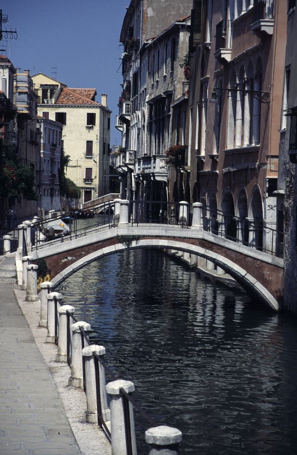 Small canal in downtown venice with bridge crossing to an apartment building. Small canal in downtown venice with bridge crossing to an apartment building