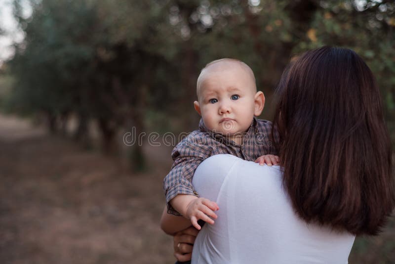 婴儿从妈妈们肩上看 孩子在女孩怀里 库存照片