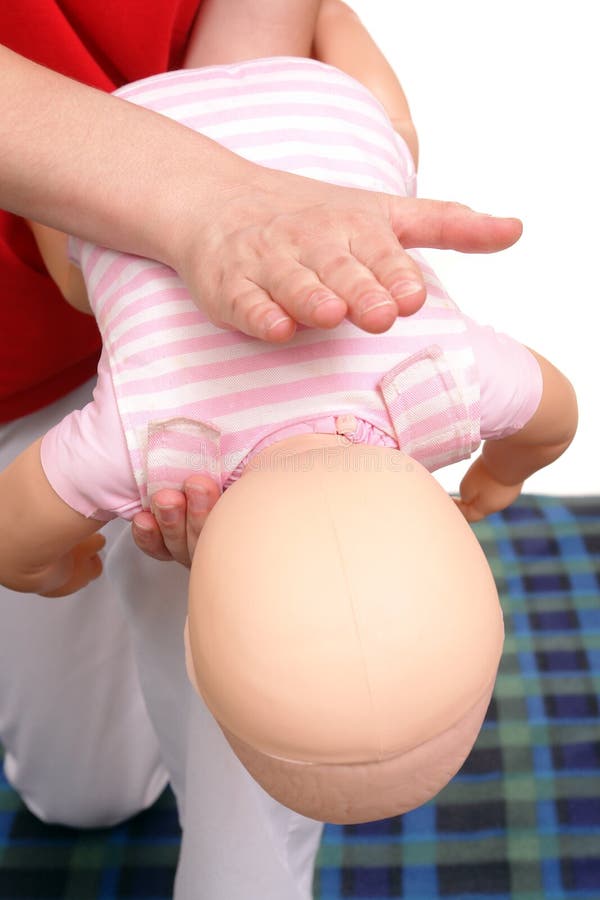 Closeup of first aid instructor using infant dummy demonstrating how to rescue a suffocating baby. Closeup of first aid instructor using infant dummy demonstrating how to rescue a suffocating baby