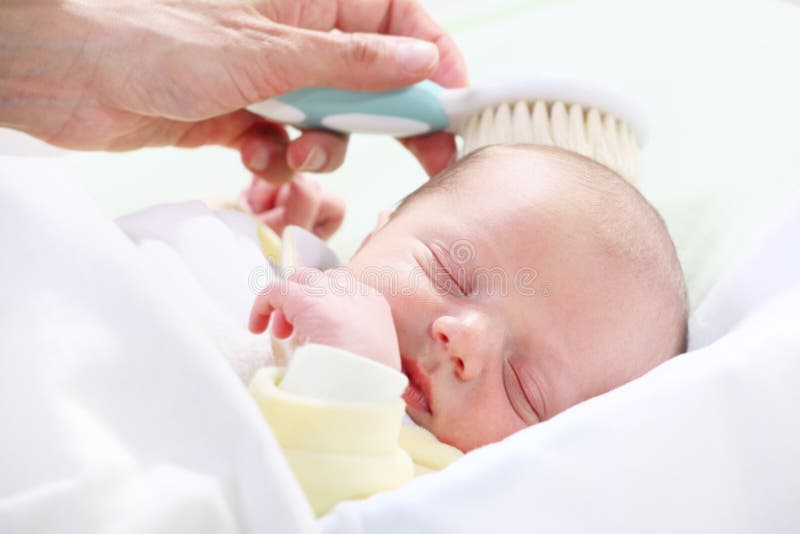 Baby hygiene - mother brushing newborn's hair. Baby hygiene - mother brushing newborn's hair