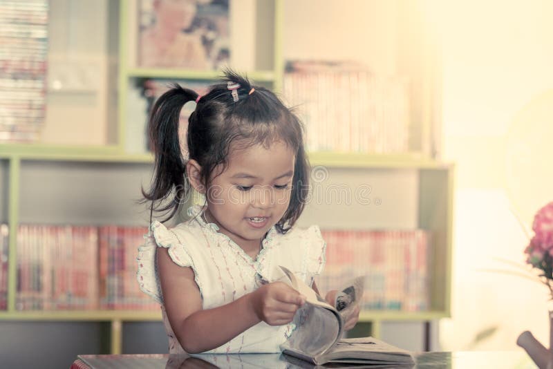 孩子读了,读书的逗人喜爱的小女孩 免版税库存图片 孩子读了,读书的逗人喜爱的小女孩 免版税库存图片