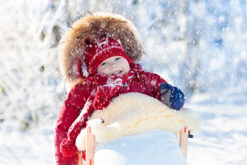 孩子的雪撬和雪乐趣 婴孩sledding在冬天公园 免版税库存照片